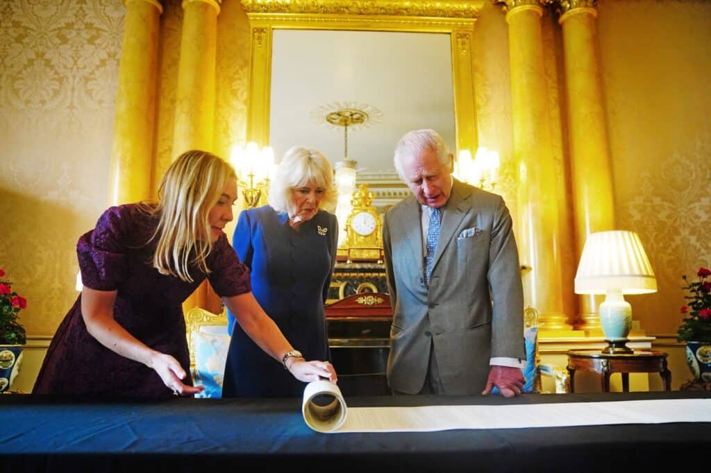 Károly király és Camilla királynő, amint a koronázási évfordulós tekercset nézik